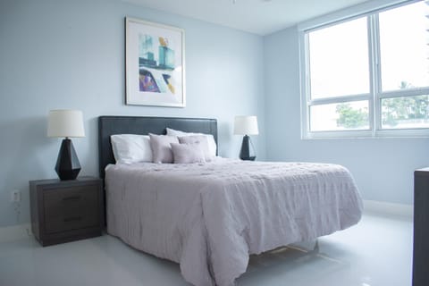 Large master bedroom with a queen size bed with ample light.