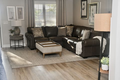 Large family room with leather sectional sofa that seats 6-7 people