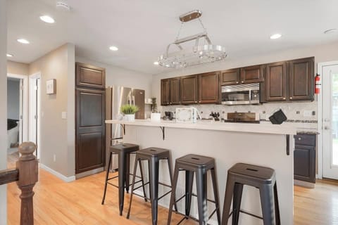 - Dark wood cabinetry and sleek stainless steel appliances bring modern warmth
- Enjoy quick bites or morning coffee at the long bar with seating for four
- Open design allows guests to cook, snack, and chat without missing a moment