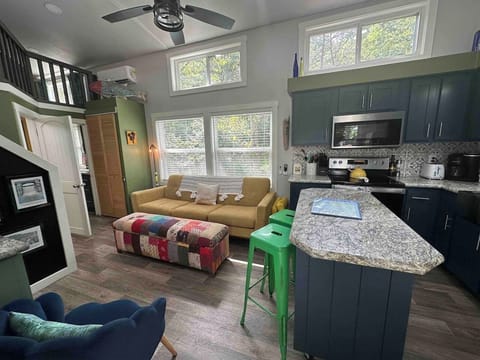 The living room and kitchen offer an open-concept layout with a Smart TV, modern appliances, and a bright, welcoming space to relax and gather.