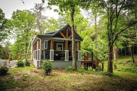 The Whimsical Waterfall Cottage is a charming and imaginative tiny home perched above a serene creek and waterfall, offering a magical escape surrounded by nature.