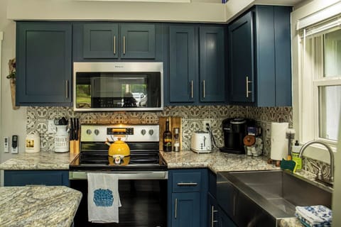 The kitchen features an electric stove and oven, microwave, and toaster, with essentials like salt, pepper, and olive oil provided.