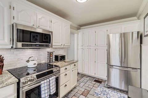 Discover a well-organized kitchen. Featuring a pantry and a full French door refrigerator, this space is perfect for storing all your culinary essentials and keeping your kitchen tidy and efficient.