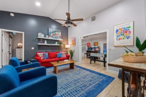 A stylish living room featuring a vibrant blue sofa and a striking red sofa, creating a perfect balance of color and comfort. The modern design is complemented by sleek furniture and soft lighting, making it an inviting space for relaxation and social gat