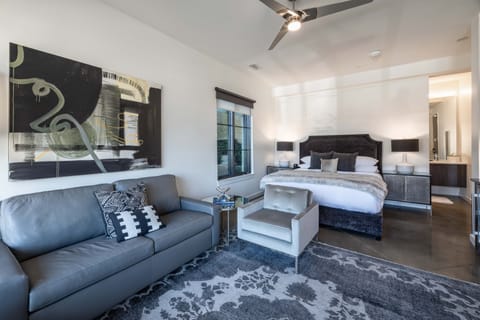 Suite style room features a spacious seating area, TV, and desk to work from home.