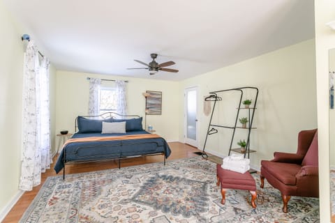 Get a good night's sleep in the primary bedroom, featuring a king size bed, overhead fan, hanging wardrobe and dedicated workspace.