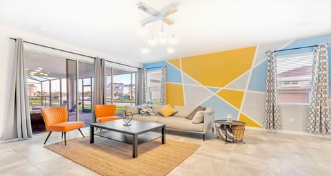 Vibrant living space with unique accent wall, modern décor, and poolside views!
