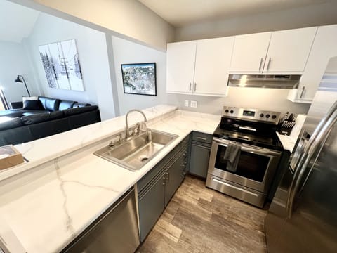 Kitchen with stainless appliances and bar seating for four