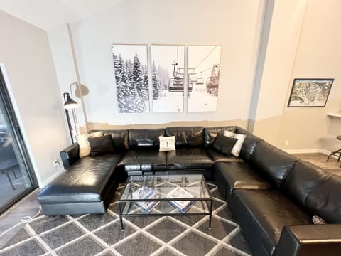 Living Room with new floors, queen sleeper sofa, gas fireplace & 65 inch TV
