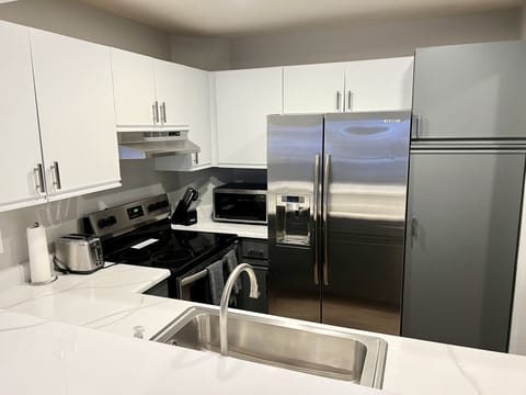 Kitchen with stainless appliances and bar seating for four