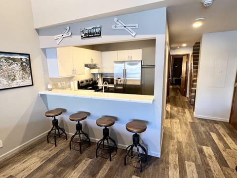 Kitchen with stainless appliances and bar seating for four