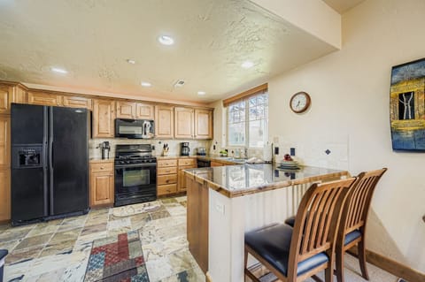Cook your favorite meals in this fully equipped kitchen featuring granite countertops, modern appliances, and a convenient breakfast bar where you can enjoy your morning coffee.