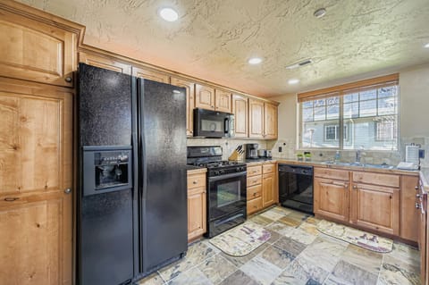 Your fully equipped kitchen features warm wood cabinets, modern black appliances, and spacious countertops perfect for preparing meals during your stay.