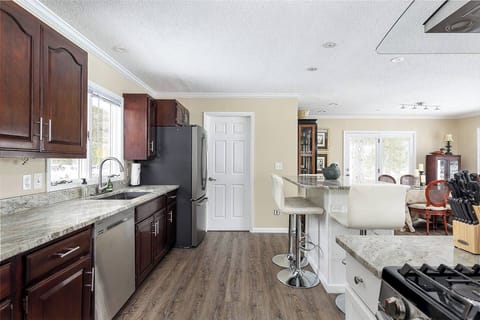 Upstairs full kitchen  with island, stocked with dishes and cooking items. 