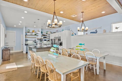 Large family-style dining space with two long tables and coastal charm.