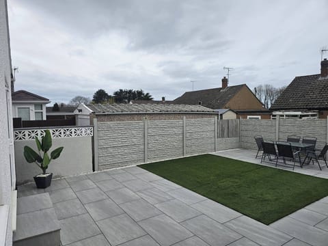 Enclosed rear garden with patio area & artificial grass. Table & chairs for Al Fresco dinning. 