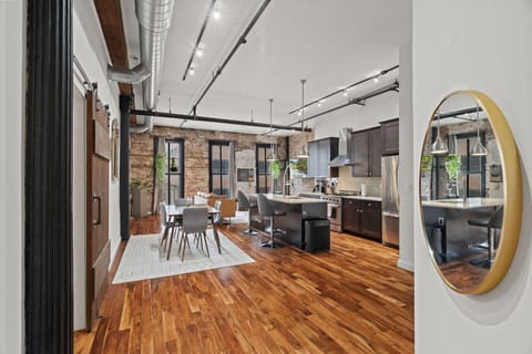 Bright, industrial-style living room with exposed brick, modern furnishings, and a brand-new smart TV.