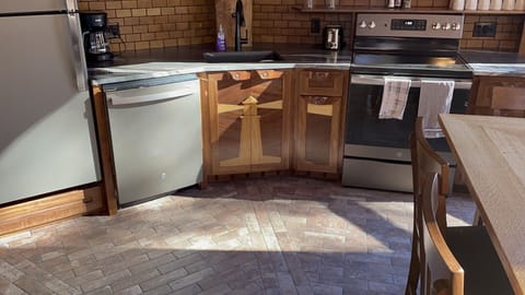 Full kitchen including cooking utensils, plates, bowls, glasses, and linens