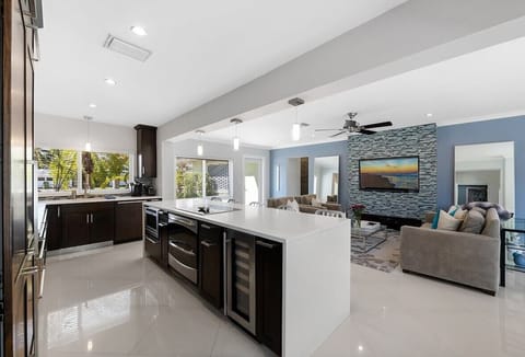 Prepare a family meal in the fully-equipped custom kitchen offering bar seating, updated appliances and pool views.