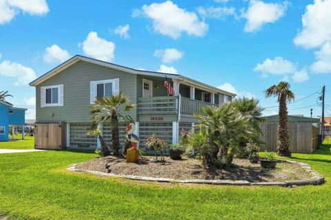 Lush landscaped yard with vibrant palms and a uniquely charming pelican statue awaits you!