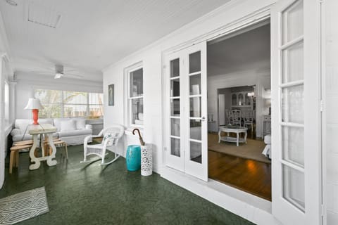 Enclosed Front Porch: Wrap-around seating, dining areas, coffee station, string lights.