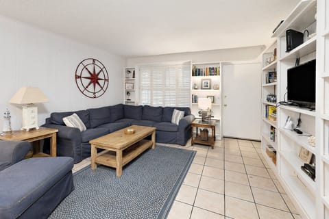 Living room with navy sectional, compass wall decor, and built-ins