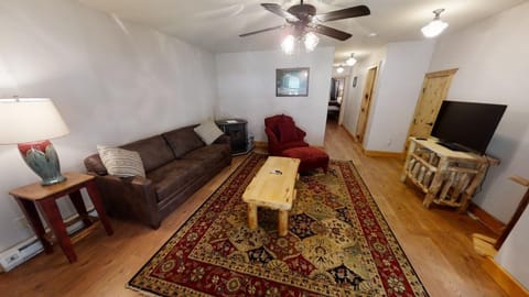 Unwind in your spacious living room with cozy seating, warm wood accents, and a ceiling fan to keep you comfortable after a day exploring.