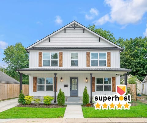 Welcome to the front of our newly constructed farmhouse, showcasing modern design with classic charm. Enjoy the inviting entryway, beautiful landscaping, and warm ambiance that set the tone for a relaxing stay.