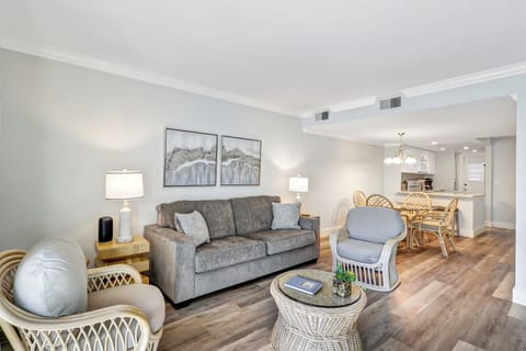 LivingRoom - The living room has a comfy sofa bed, wall mounted smart flat screen T.V. and sliding door to balcony with amazing Beachfront view and Palm trees.
