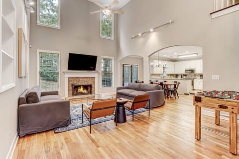 Living room feat. 65" Roku Smart TV, plush seating, and foosball table