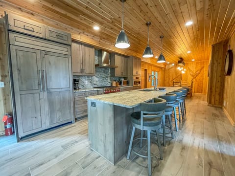 The home has a spacious chef's kitchen complete with a 6-burner range and a refrigerator and dishwasher that blend in with the custom cabinetry.