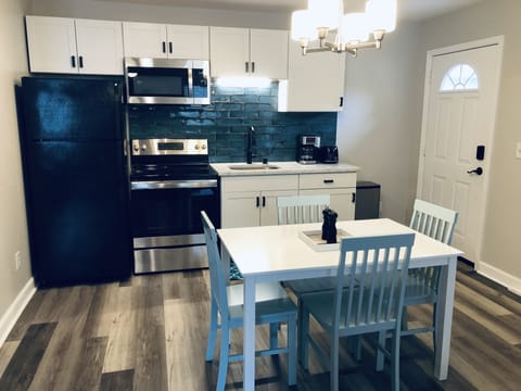Newly renovated kitchen with new range and micro, dinette, cookware/dish ware.