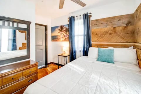 Comfy bedroom with custom wood paneling.  Ceiling fan with remote. 