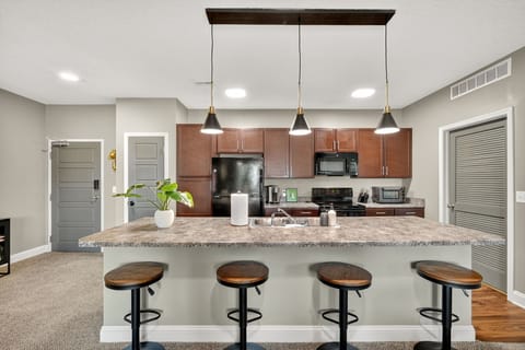 Gather around the kitchen island with seating, modern black pendant lights, and warm wood finishes. The true modern-style design sets this home apart, blending style and function.