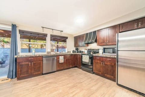 Dishwasher, oven, stove with vent, fridge, and freezer. Additional cooking appliances, cutting boards, knives, glasses, and everything you would expect at home located throughout the kitchen.