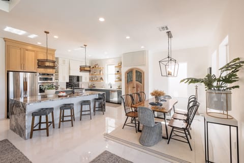 Kitchen & Dining Room View - The kitchen is fully stocked with all the dishes, cookware, baking pans, and cutlery you will need for meal preparations and includes stainless steel appliances and marble counter tops.