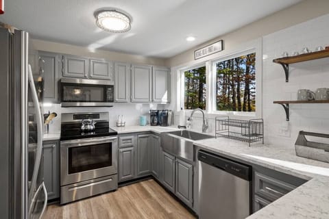 Kitchen with all stainless steel appliances and large modern farm house sink.