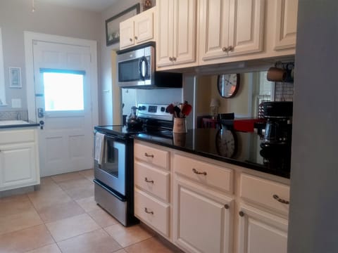 A very well equipped kitchen with granite countertops and stainless appliances.