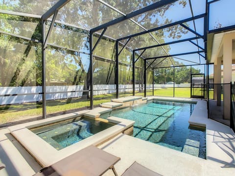 Screened backyard with pool and spa