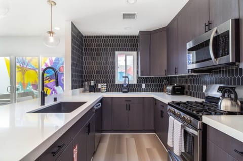 This kitchen is fit for any chef... stainless steel appliances and white quartz waterfall counters