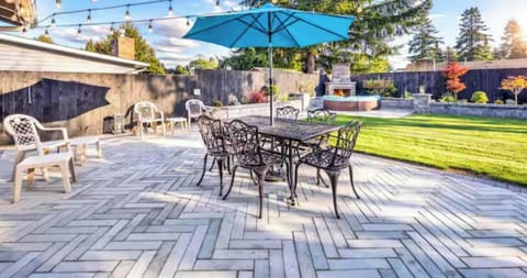 Beautiful outdoor patio featuring a dining set, cozy lighting, and a peaceful backyard setting.