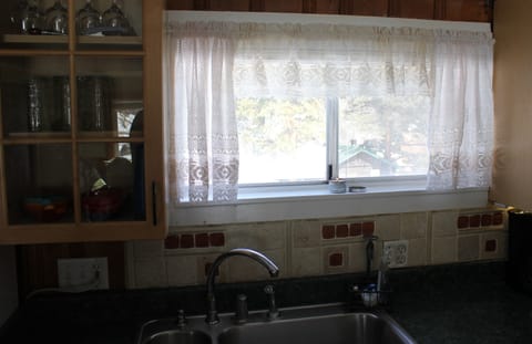 Kitchen views show other cabins in the foreground with mountain peaks behind.