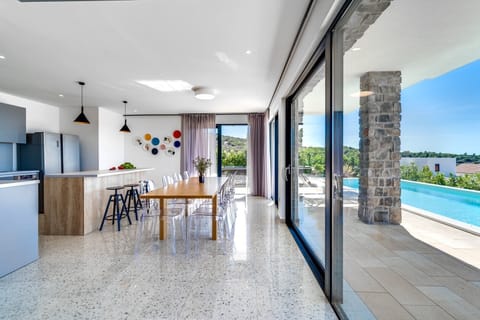 A fully equipped kitchen with direct connection with outdoor dining and pool area.