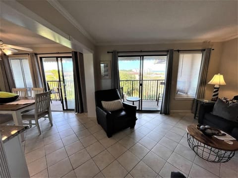 A bright, open-concept living room featuring tiled flooring.