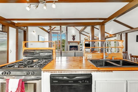 Kitchen has oven with stove top along with dishwasher and a kettle for tea.