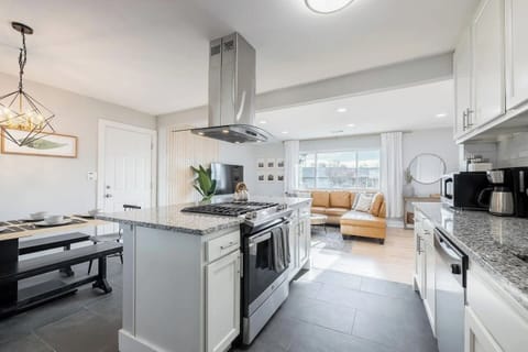 - Open concept layout lets you cook while staying connected to the living room
- Center island with gas range & bar seating creates the perfect space for entertaining
- Clean lines, bright tones & stylish fixtures tie the kitchen & lounge beautifully