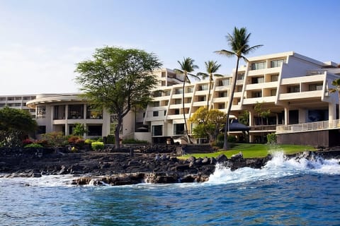 Stroll seaside pathways beside modern buildings and crashing waves.