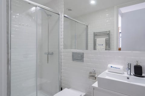 The bathroom is equipped with towels, hair dryer and shampoo.