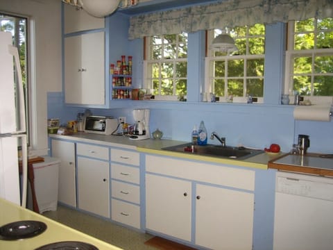 Big House kitchen filled with cooking equipment, dishes, cutlery, microwave