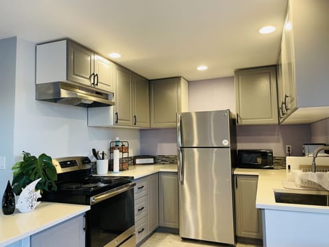 Modern kitchen with microwave, coffee machine, bread toaster & more.